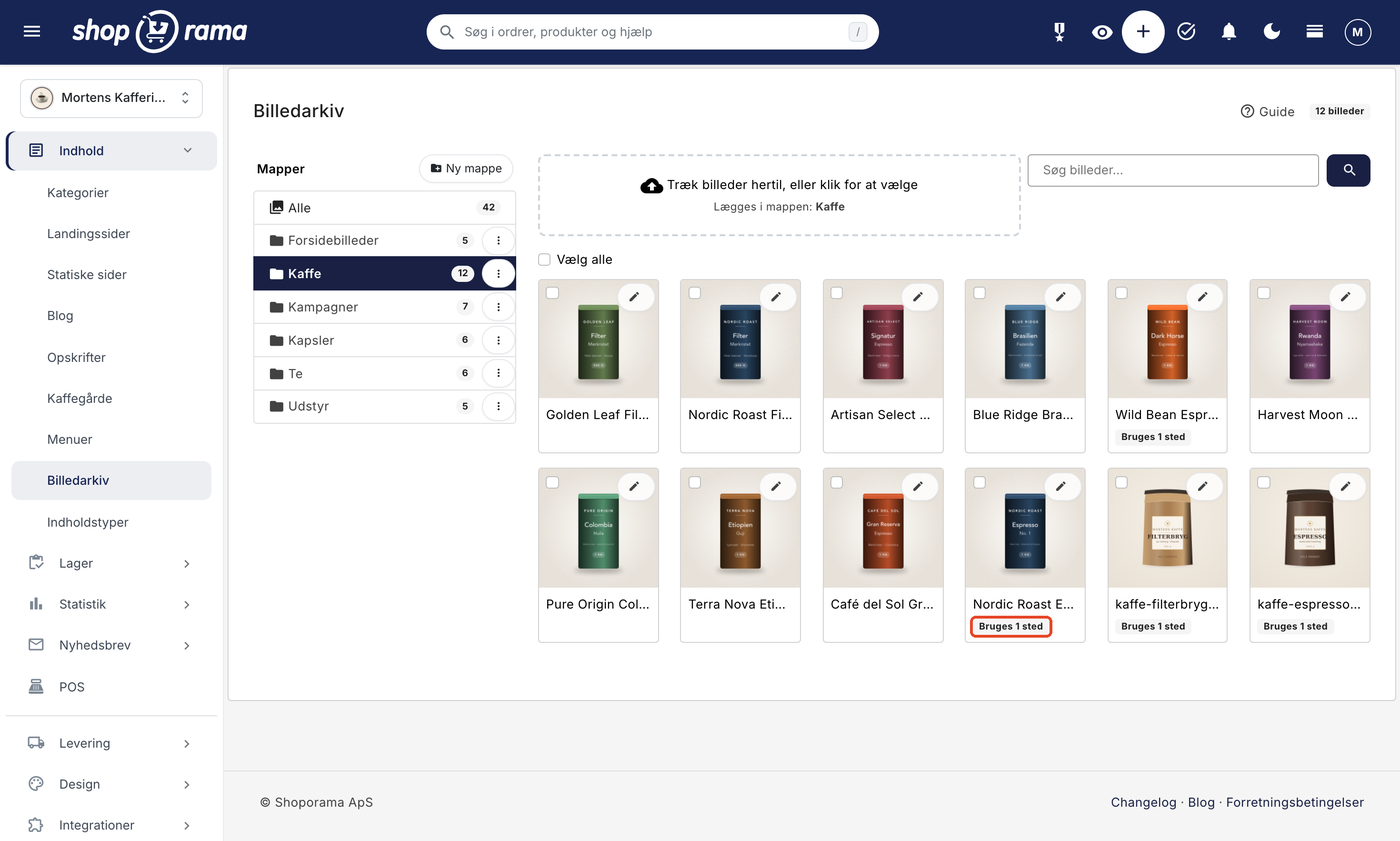 Billedarkivet i Shoporama, åbnet under Indhold i menuen, med mappen Kaffe valgt blandt mapperne til venstre, et upload-felt og søgefelt øverst, og et galleri af tolv kaffeposer og -dåser, hvor fire af billederne har mærket Bruges 1 sted, det ene markeret med en rød ramme